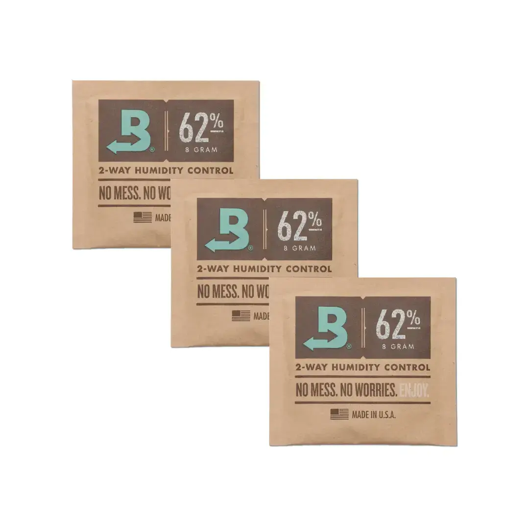 kit-3-unidades-sache-boveda-62%-8g O pacote de Boveda é retângular, e tem a cor parda. Existe uma impressão na frente descrevendo as características do produto.