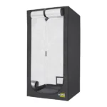 Visão diagonal da estufa de cultivo Garden HighPro. O produto é retangular e feito de material preto. Através da porta da tenda, que está aberta, é possível ver que o material interior é refletivo, na cor prateada. Além disso, existem diversos buracos para instalação de exaustores de ar.
